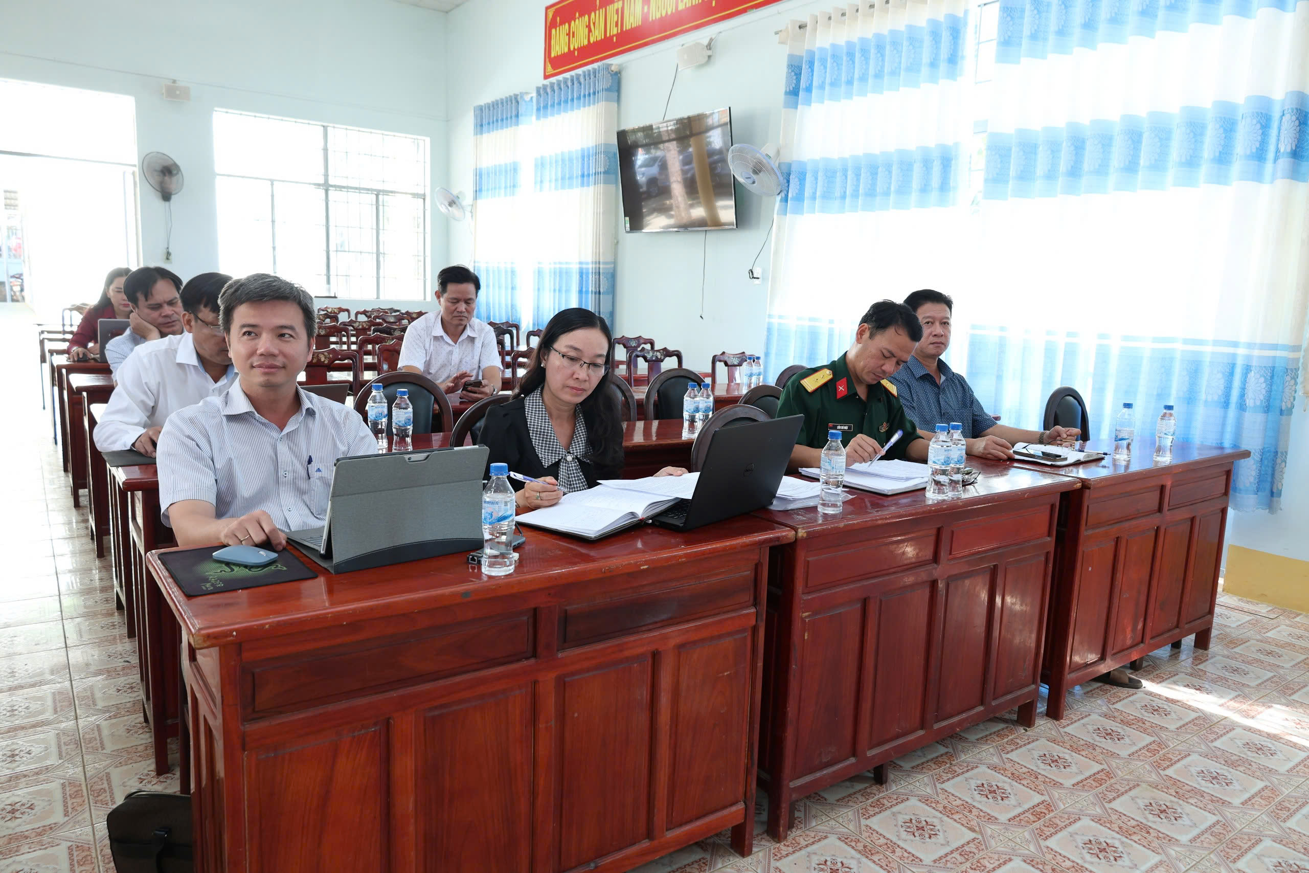 'A group of people sitting at desks in a room

Description automatically generated'