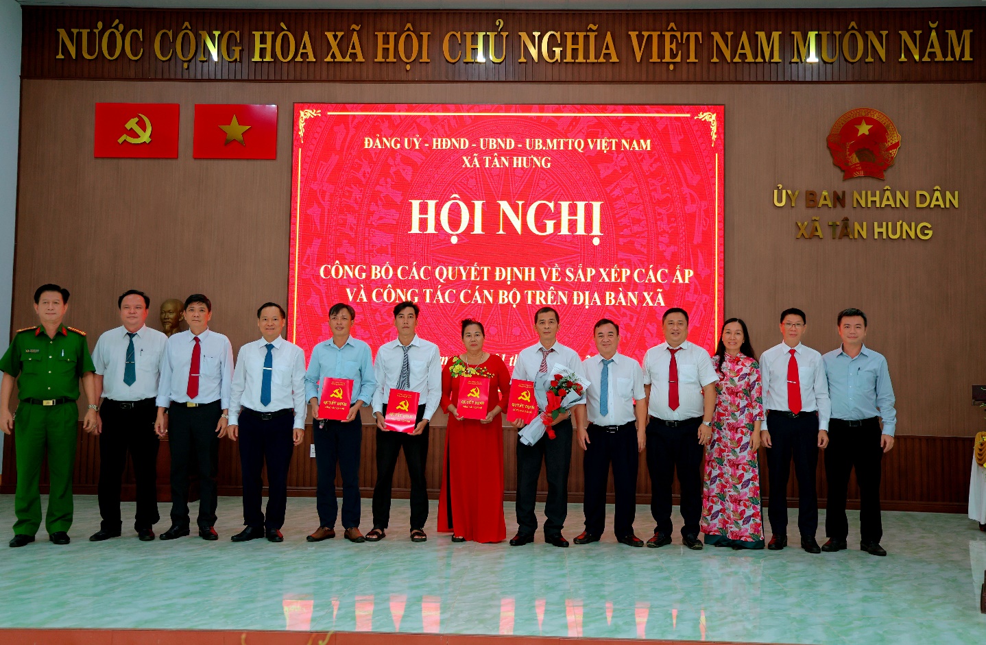 'A group of people standing in front of a sign

Description automatically generated'