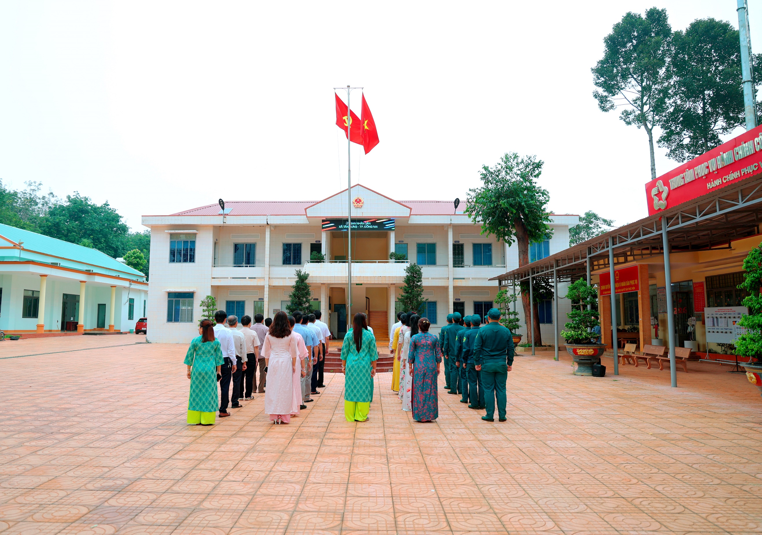'''A group of people standing in front of a building

Description automatically generated'''