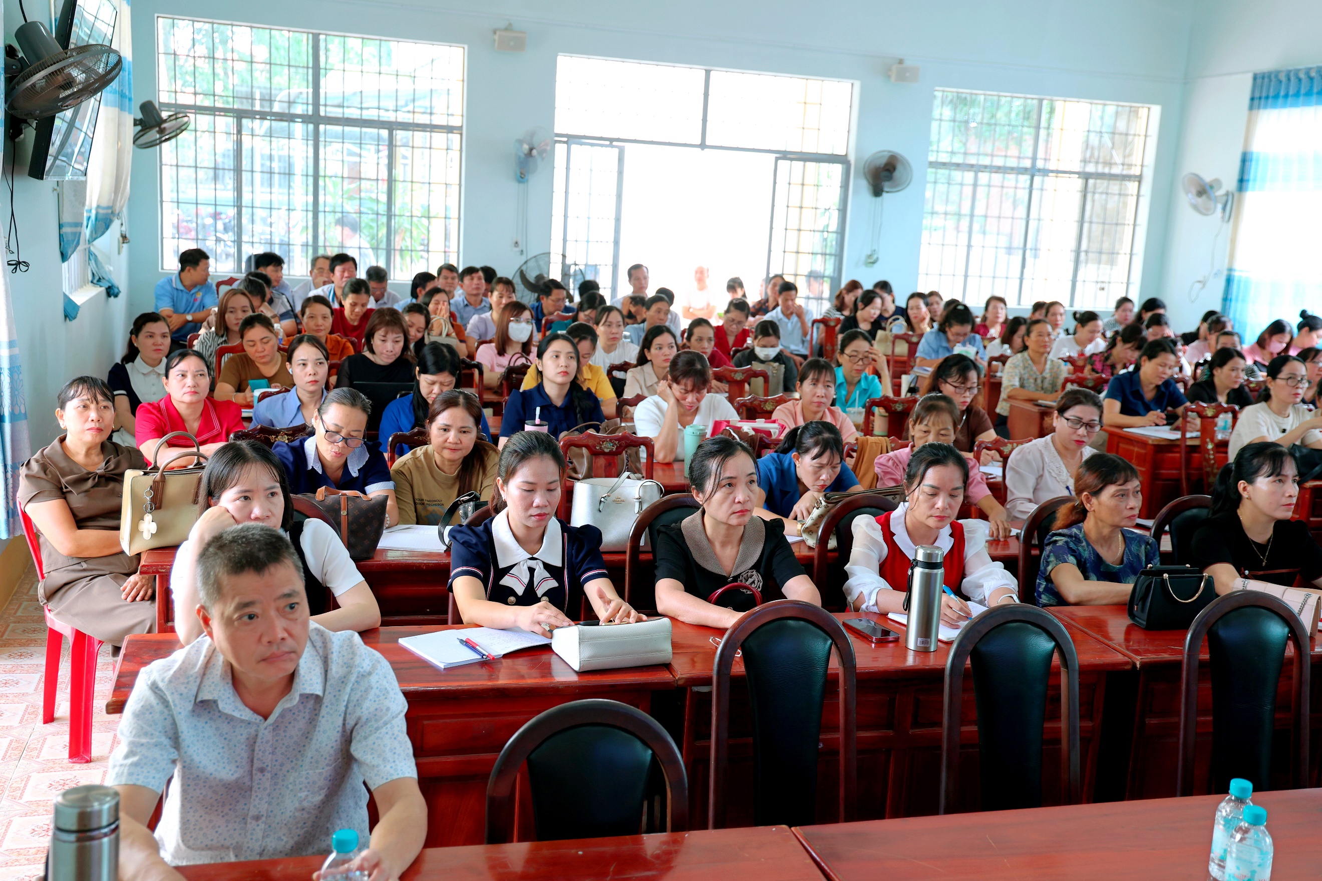 'A group of people sitting in a classroom

Description automatically generated'