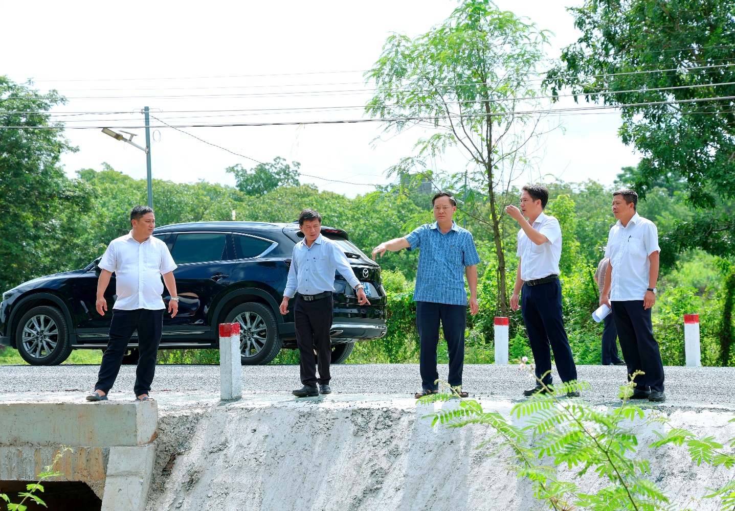 A group of men standing on a concrete ledge

Description automatically generated