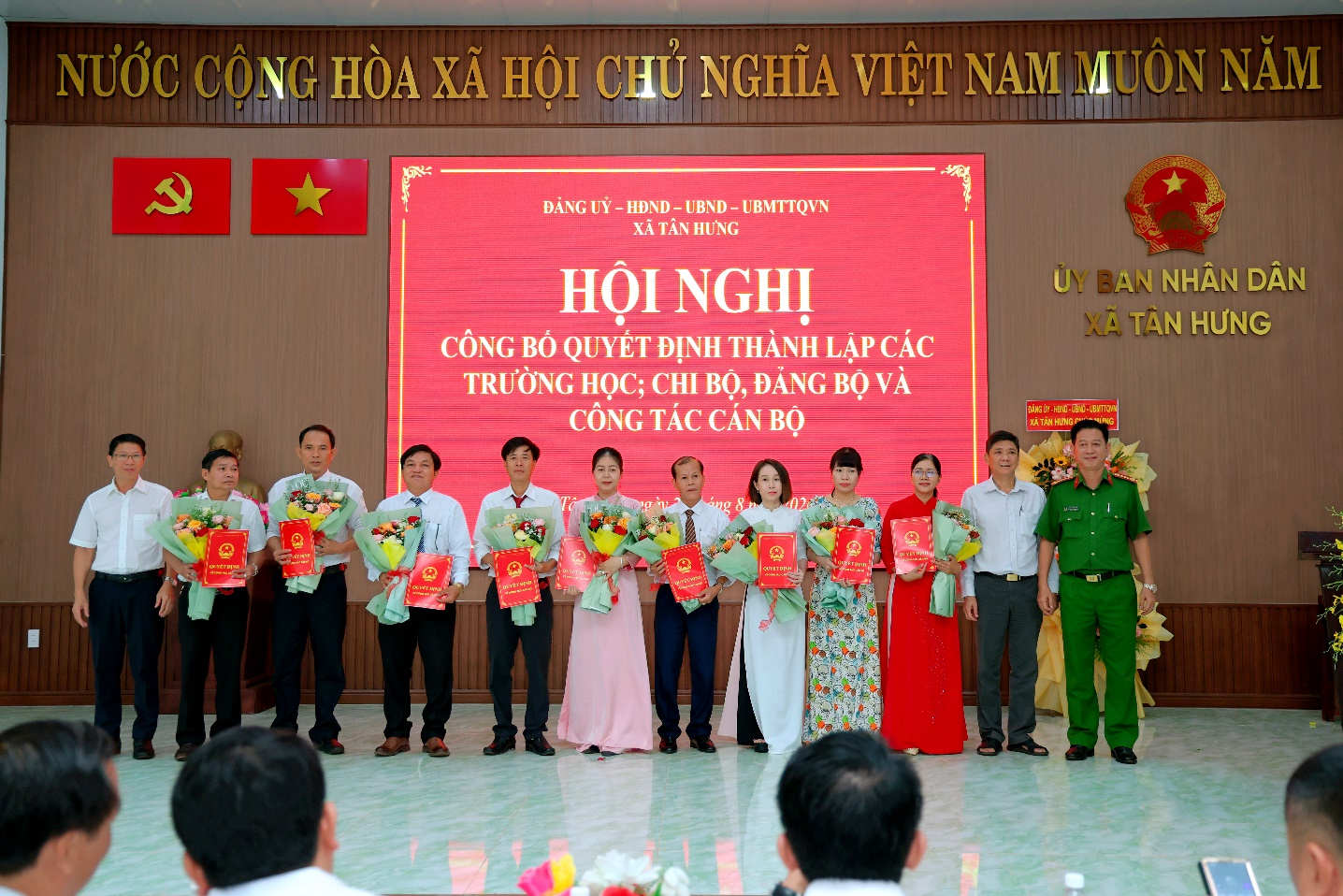 A group of people holding flowers

Description automatically generated
