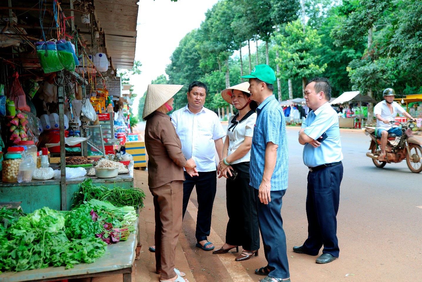 A group of people standing outside a market

Description automatically generated