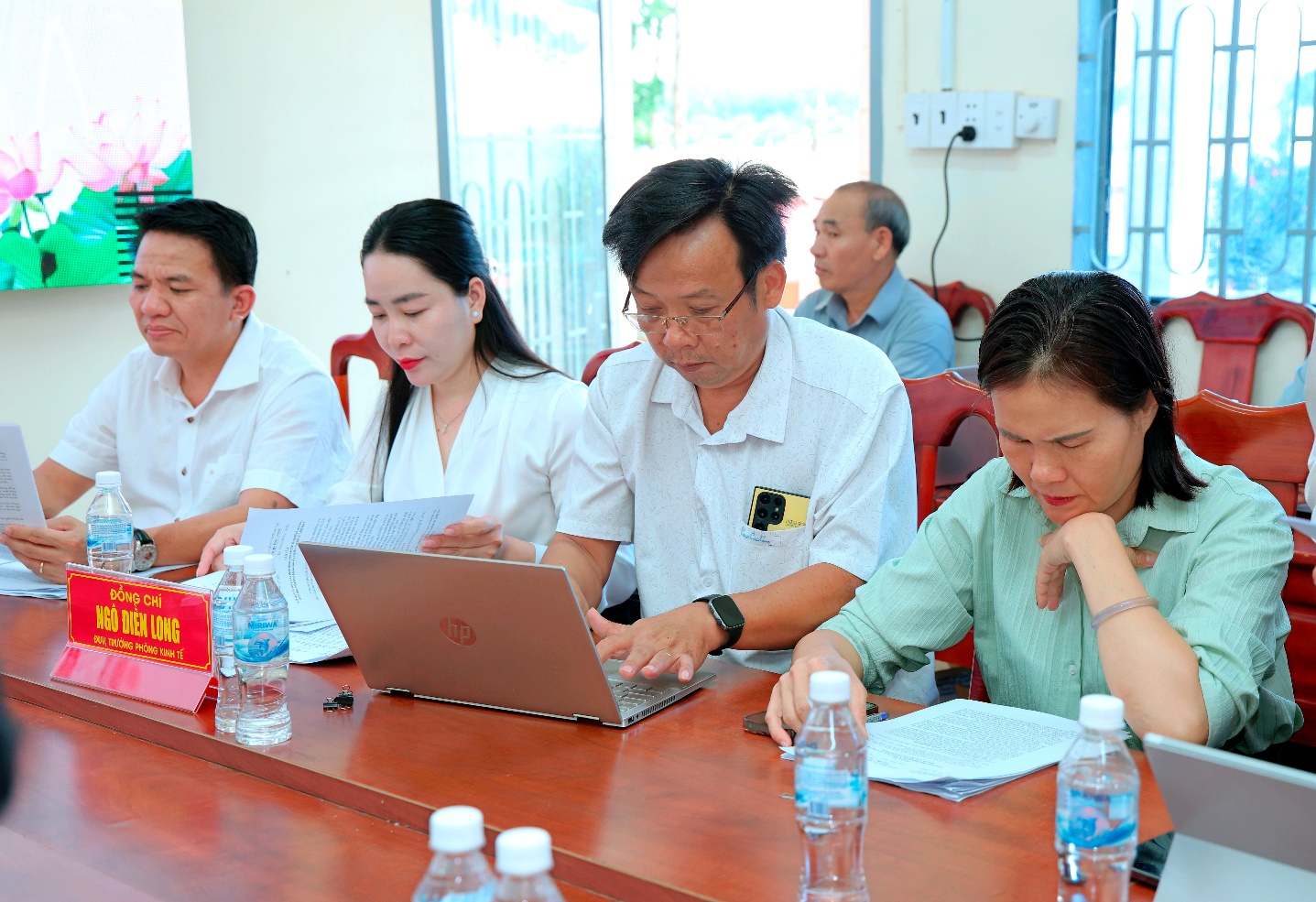 A group of people sitting at a table looking at a computer

Description automatically generated