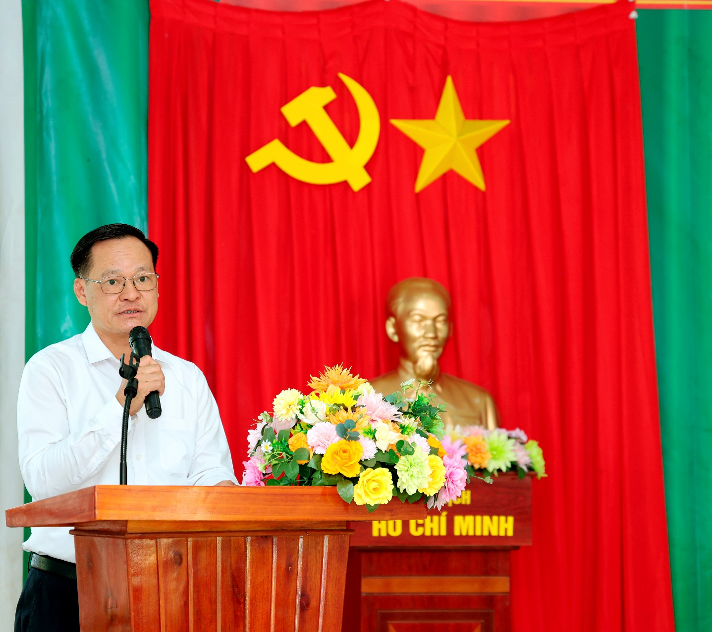 A person standing at a podium with a microphone

Description automatically generated