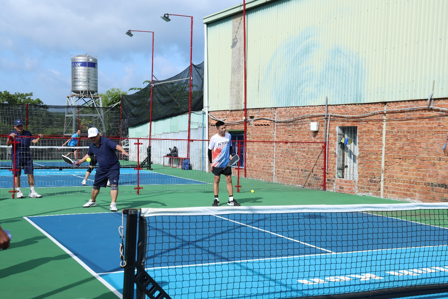 A group of people playing tennis

Description automatically generated