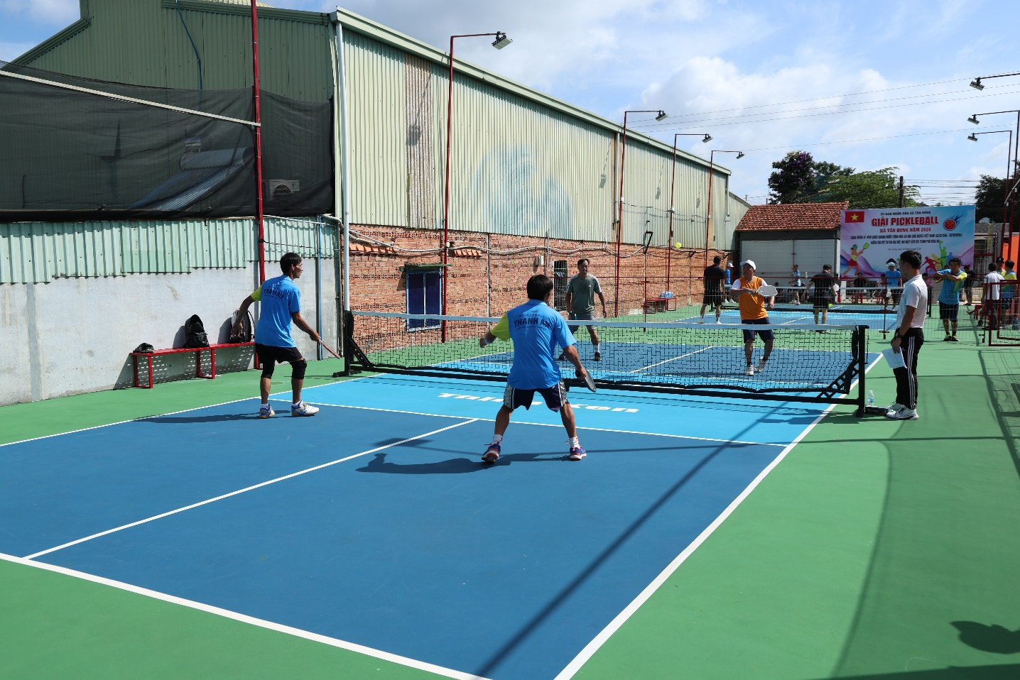 A group of people playing tennis

Description automatically generated