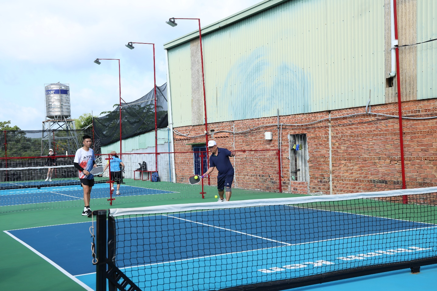 A group of people playing tennis

Description automatically generated