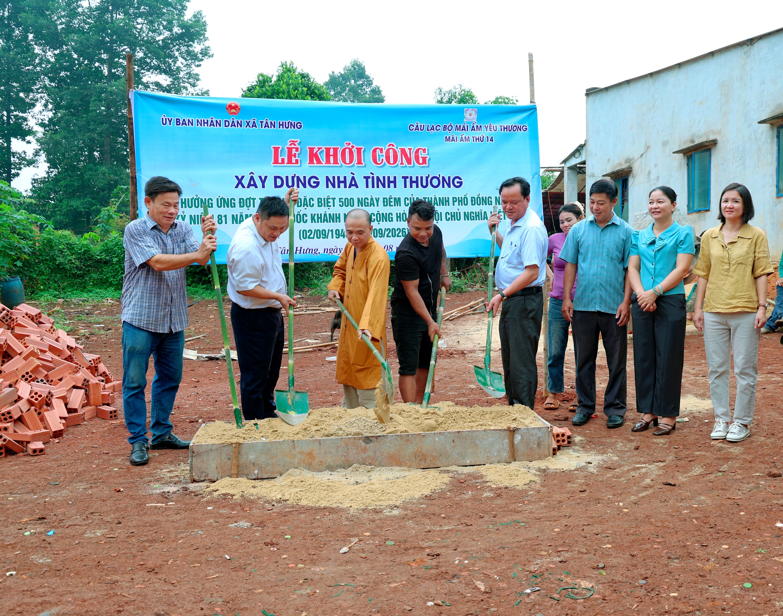 'A group of people standing around a pile of dirt

Description automatically generated'