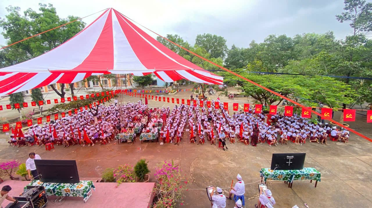 A large group of people under a red and white tent

Description automatically generated