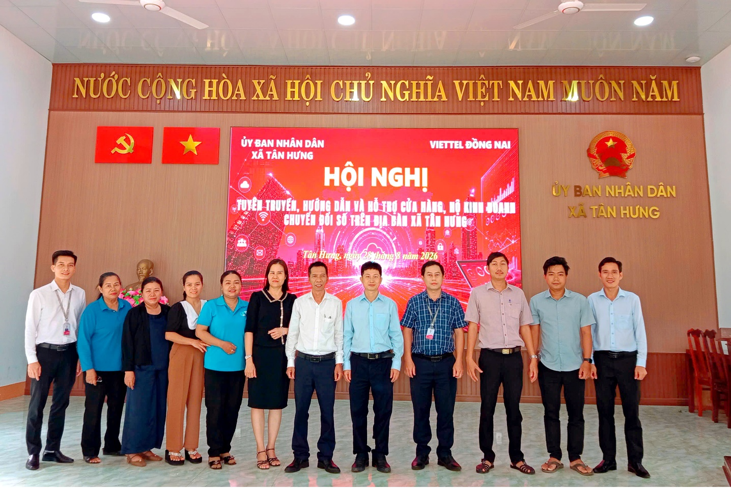 A group of people standing in front of a sign

Description automatically generated