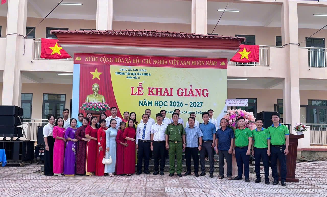 A group of people standing in front of a banner

Description automatically generated